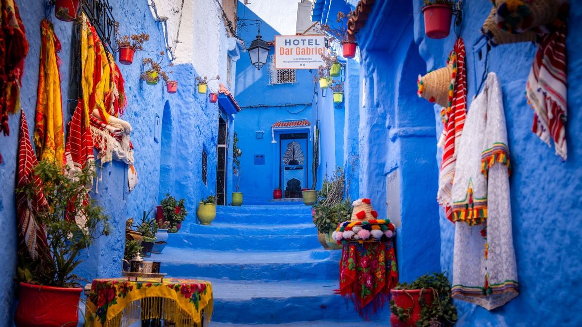 Blue steps decorated with pots and textiles in Chefchaouen