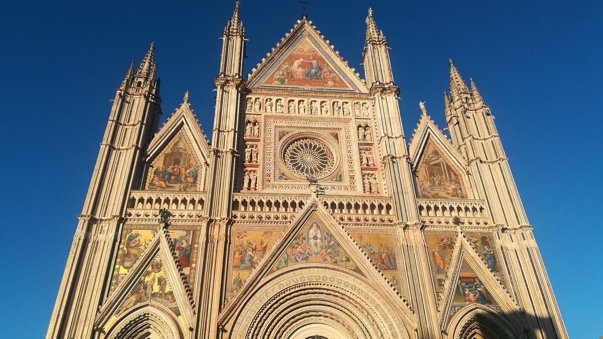 The ornate facade of Orvieto Cathedral at sunset