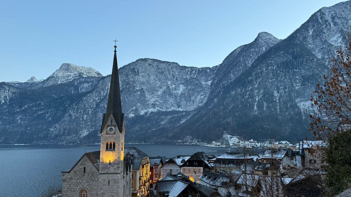 Hallstatt church and village by the lake under snowy peaks