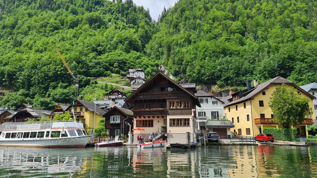 Lakeside houses and boats in Hallstatt below green mountains