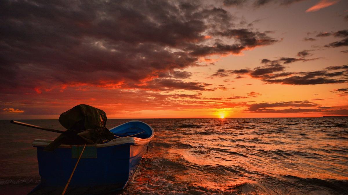 A small boat on a Cambodian beach at sunrise