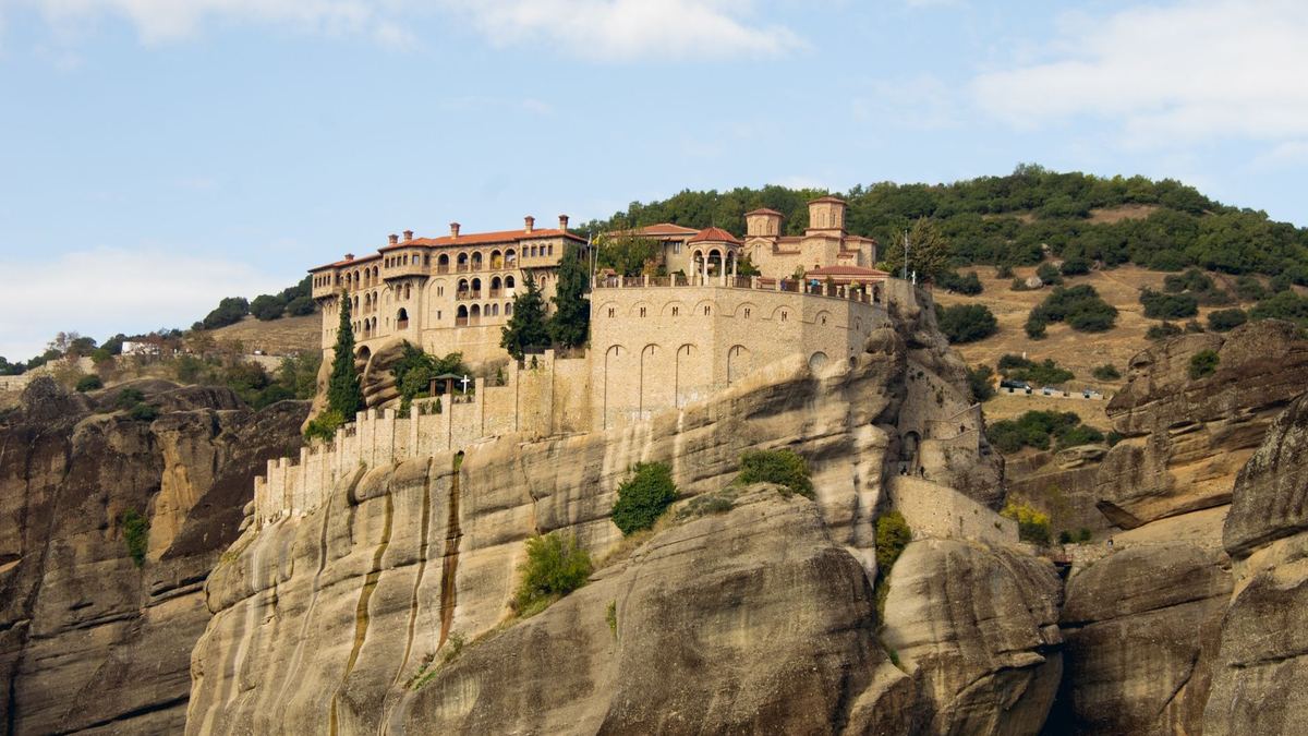 Varlaam monastery on top of a sandstone cliff under a blue sky