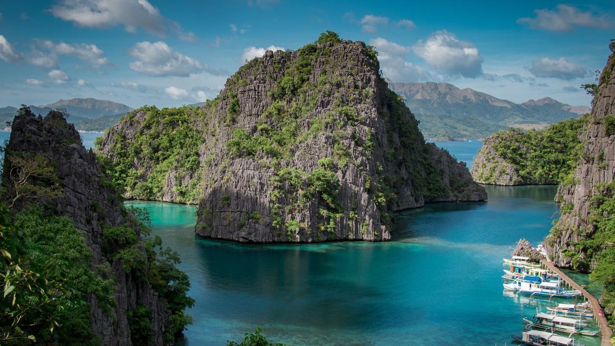 Turquoise water, limestone cliffs and boats at Coron