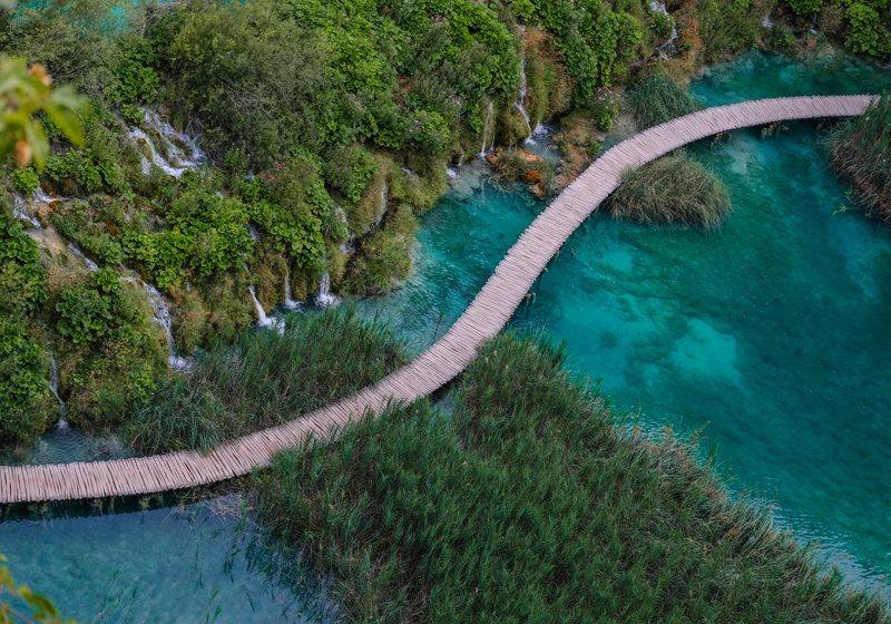 A wooden boardwalk across turquoise water at Plitvice Lakes